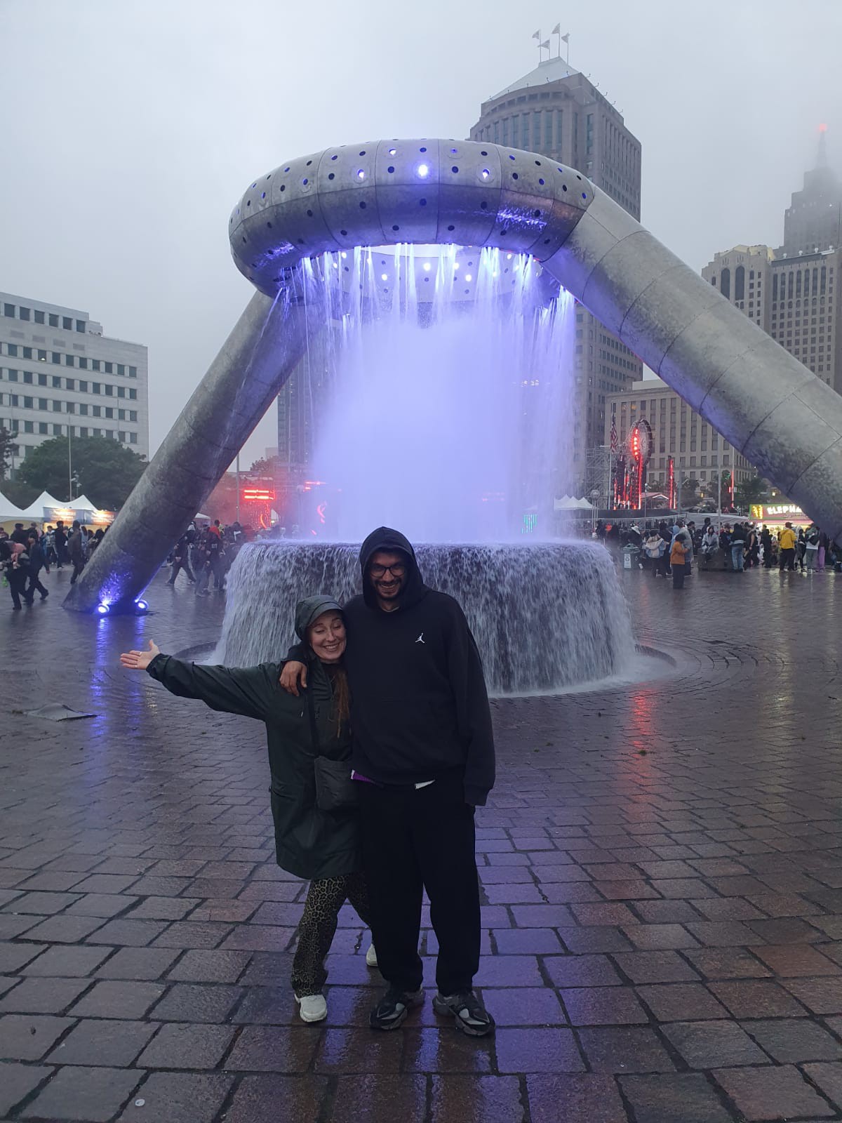 The two of us in front of a lit fountain on a rainy evening